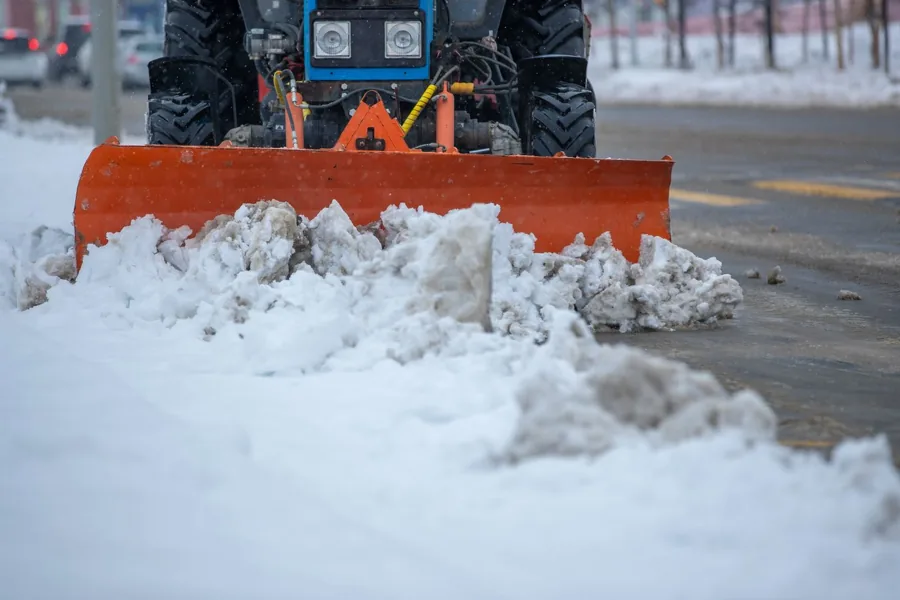 Snowplow clearing snow from a paved surface